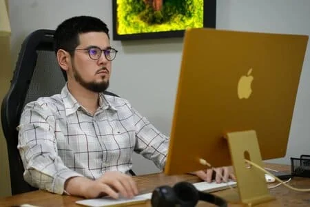 Специалист ABC Design работает за компьютером Apple
